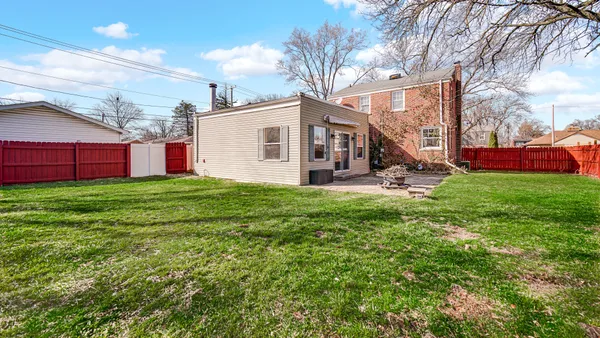 a view of a house with a yard and sitting area