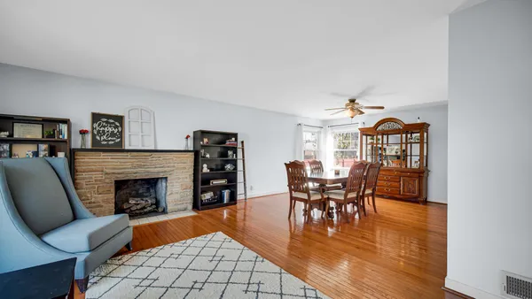a dining room with furniture wooden floor a fireplace and a chandelier