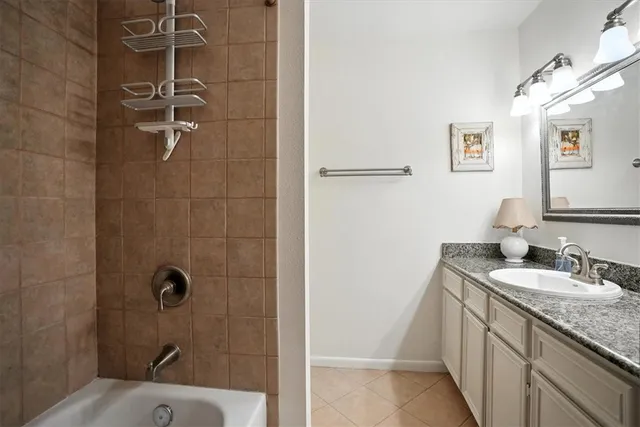 a bathroom with a granite countertop sink a mirror and shower