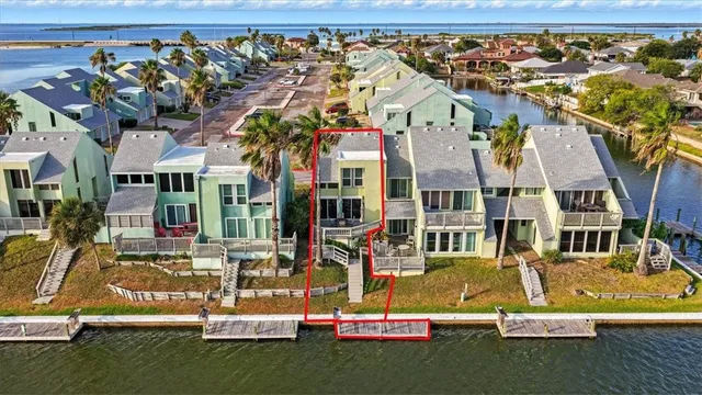 an aerial view of residential houses with outdoor space and parking