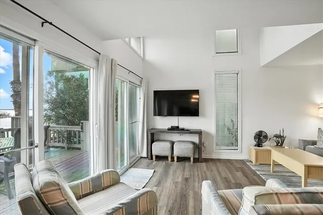 a living room with furniture a flat screen tv and a floor to ceiling window
