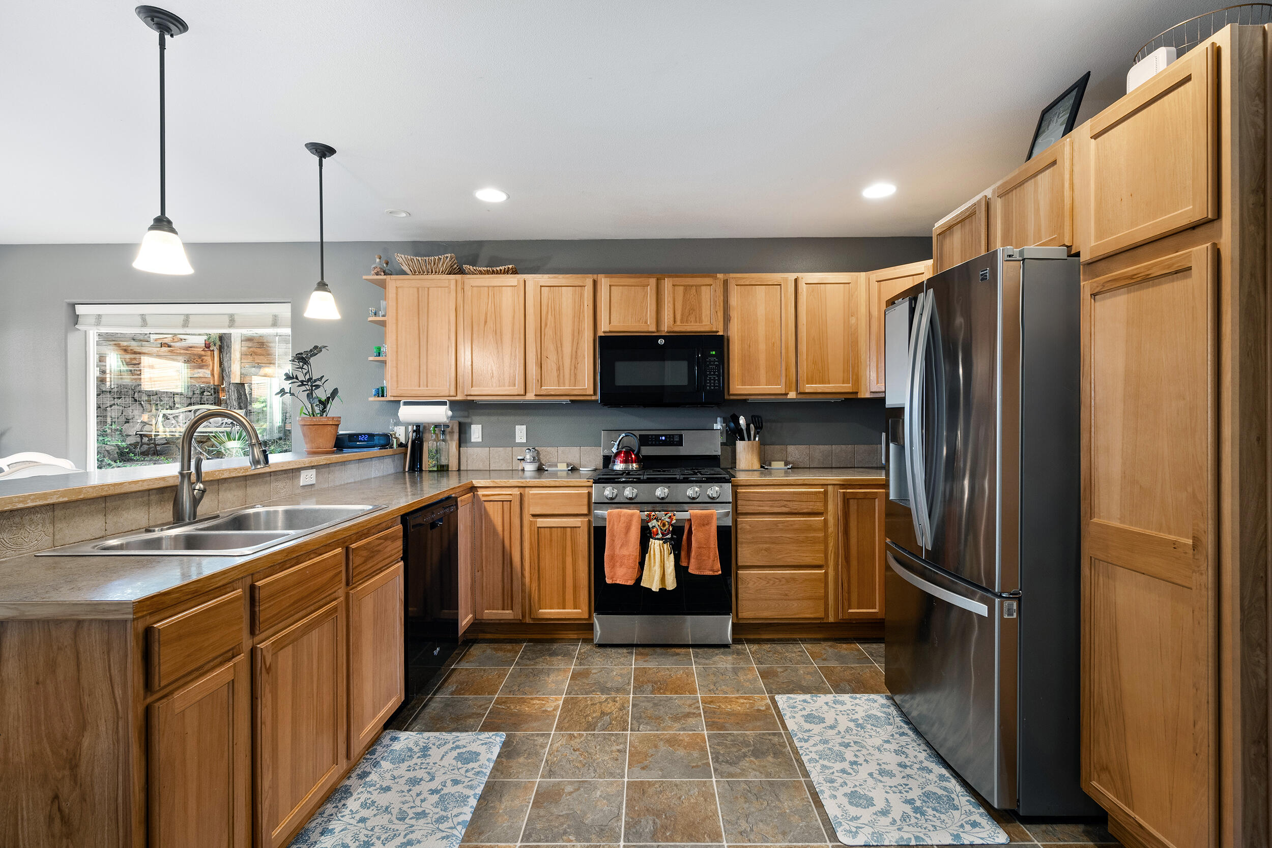 62906 Bilyeu Way Bend, OR 97701 - Photo 60 of 100 a kitchen with stainless steel appliances granite countertop a refrigerator a sink a stove a microwave and island with wooden floor