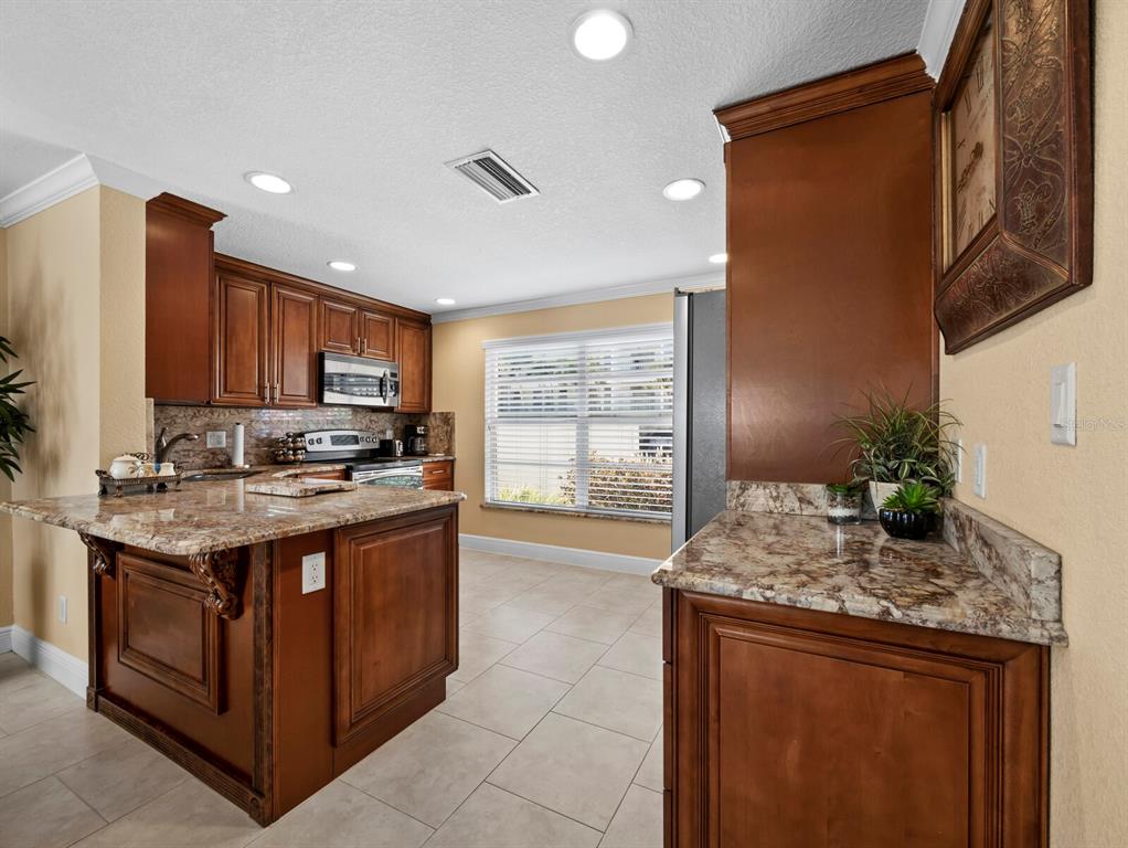 4430 Exeter Drive, Unit M108 Longboat Key, FL 34228 - Photo 15 of 65 a kitchen with stainless steel appliances granite countertop a stove and a sink