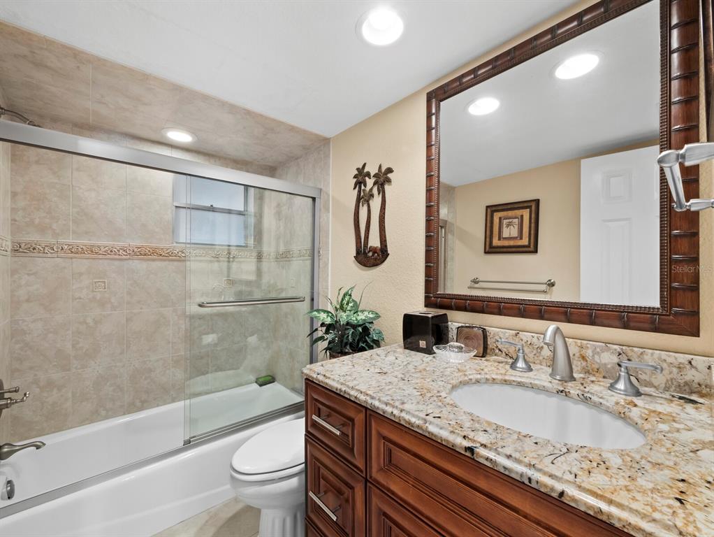 4430 Exeter Drive, Unit M108 Longboat Key, FL 34228 - Photo 19 of 65 a bathroom with a granite countertop sink a toilet and bathtub