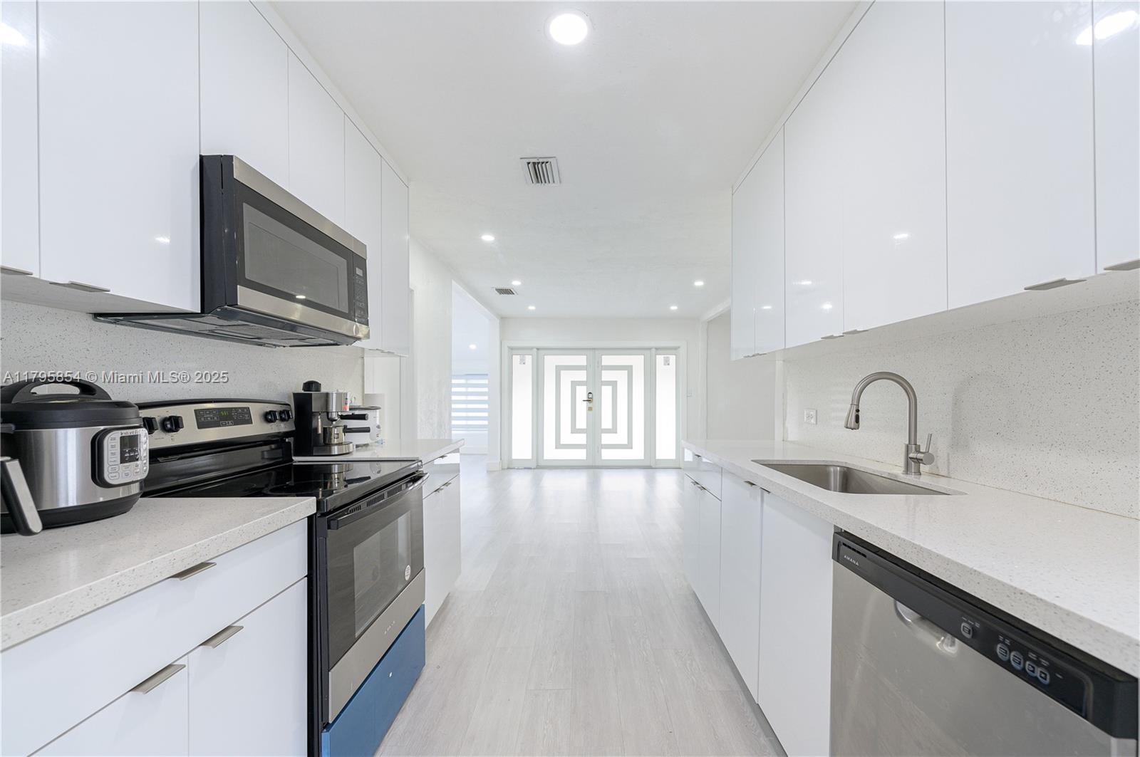 5200 Southwest 4th Street Miami, FL 33134 - Photo 18 of 35 a kitchen with stainless steel appliances a sink dishwasher stove microwave and cabinets