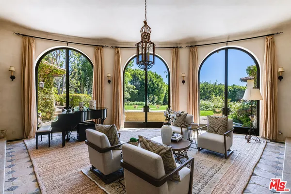 a living room with couches chairs and a dining table with wooden floor