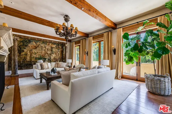 a living room with furniture a fireplace and a chandelier