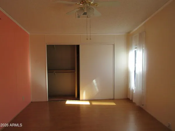 an empty room with a ceiling fan and window