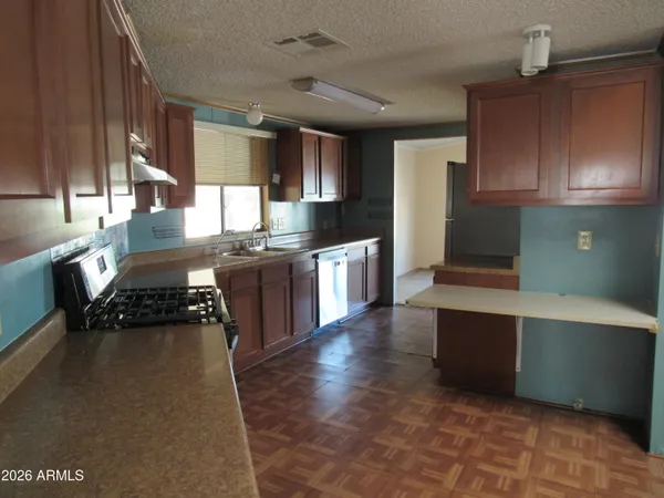 a kitchen with stainless steel appliances granite countertop a stove a sink and a refrigerator