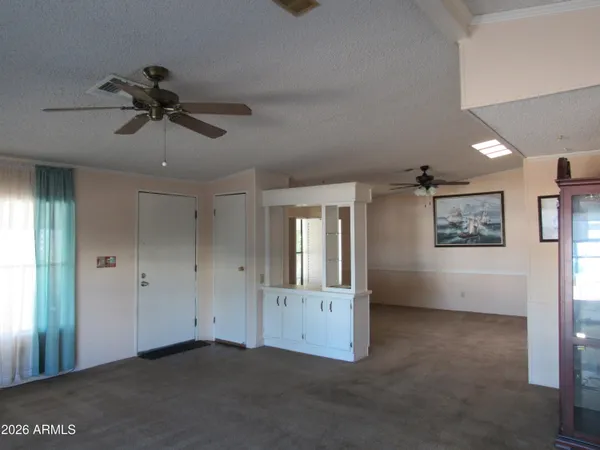 a view of a livingroom with a chandelier fan and windows