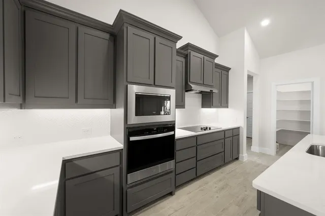 a kitchen with stainless steel appliances granite countertop a sink and a stove top oven