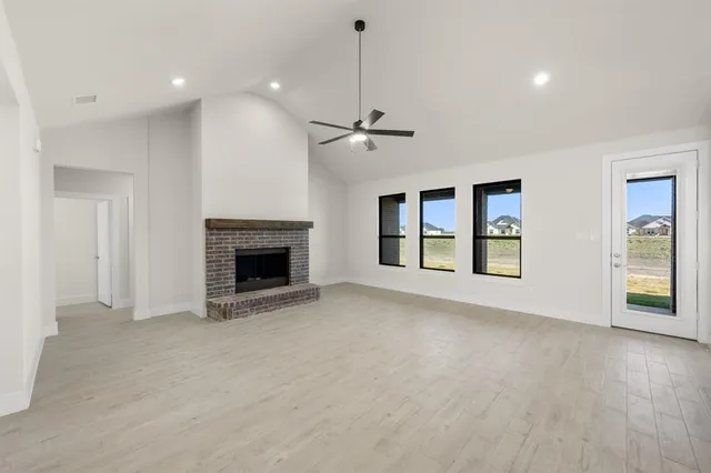 a view of an empty room with a fireplace and a window