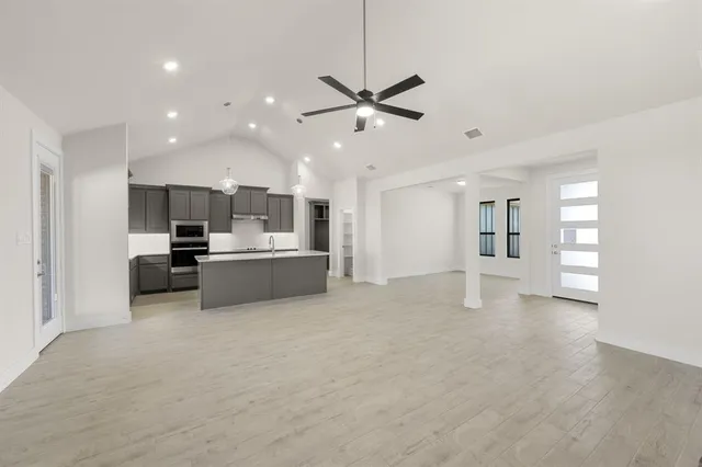 a view of a kitchen with refrigerator and a sink