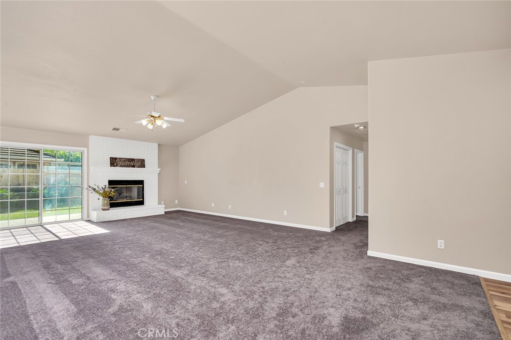 3546 Joerg Avenue Merced, CA 95340 - Photo 12 of 51 en empty room with a fireplace and windows