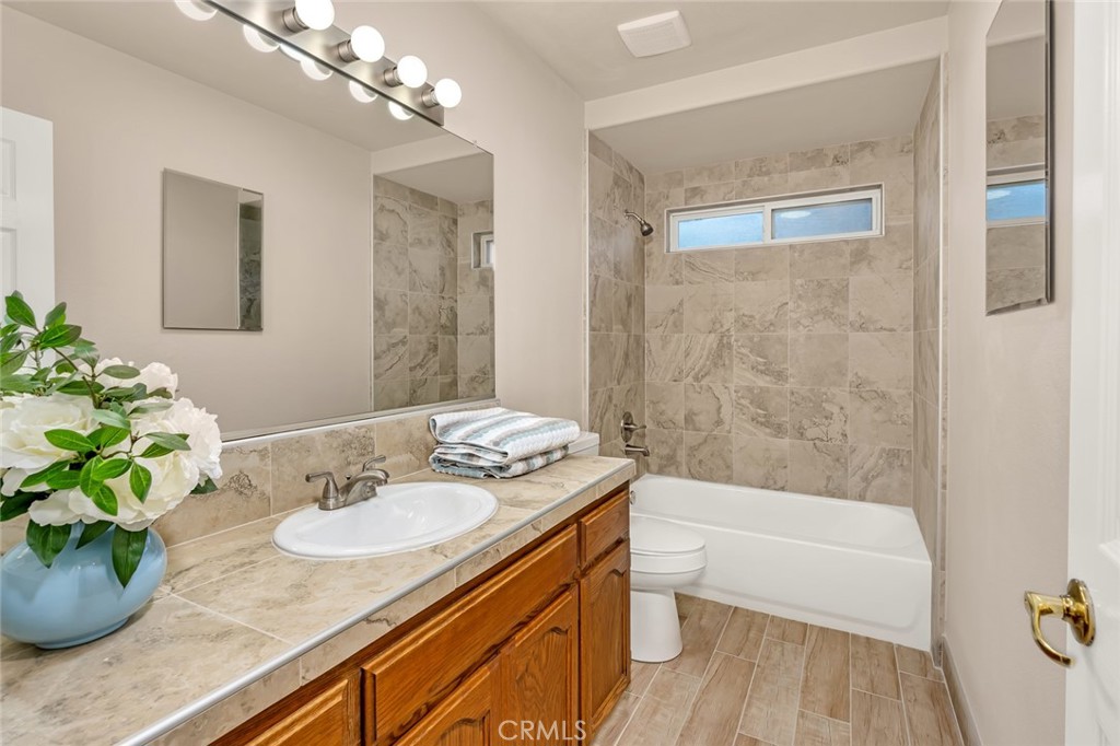 3546 Joerg Avenue Merced, CA 95340 - Photo 39 of 51 a bathroom with a granite countertop sink a toilet a mirror and shower