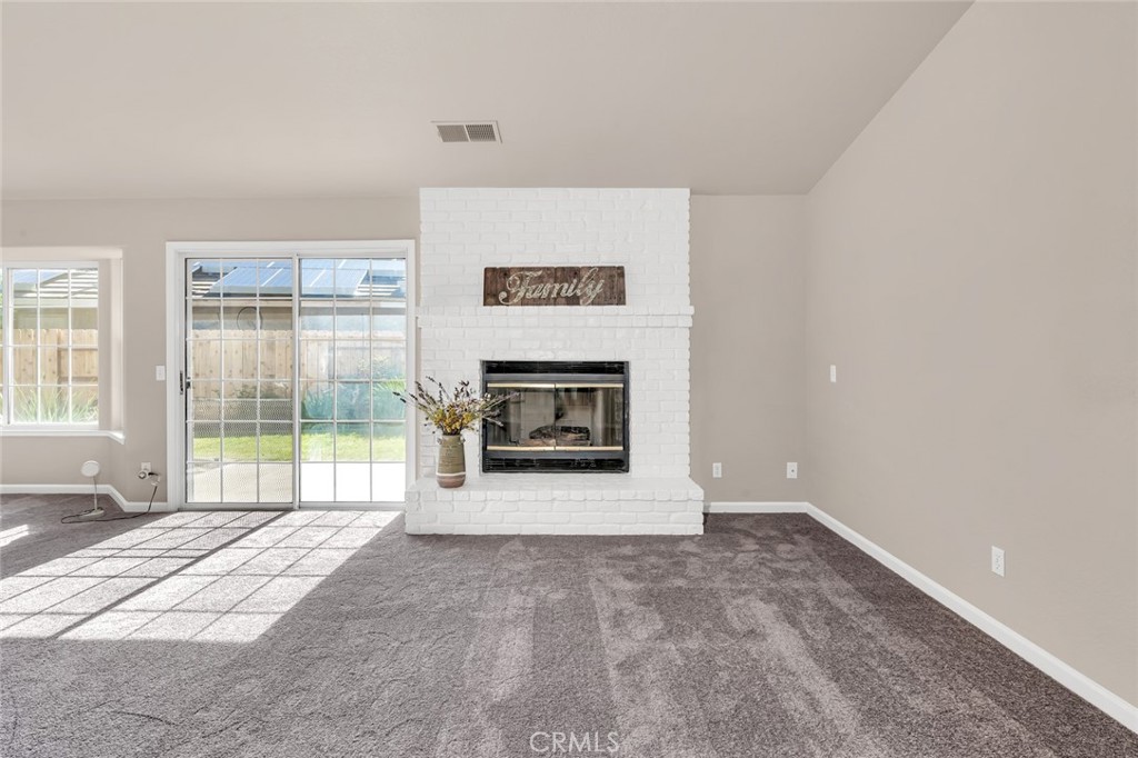 3546 Joerg Avenue Merced, CA 95340 - Photo 9 of 51 a view of an empty room with a fireplace and a large window