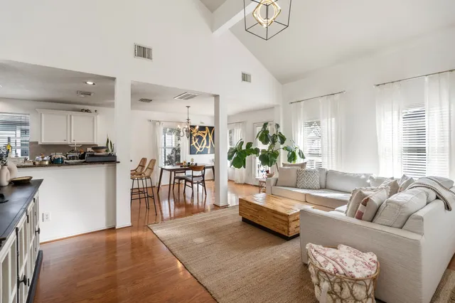 a living room with furniture and a dining table with kitchen view