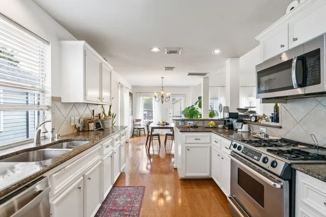 a kitchen with stainless steel appliances a stove sink cabinets and microwave