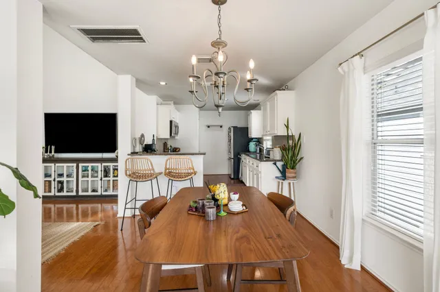 a view of a dining room with furniture a chandelier and wooden floor