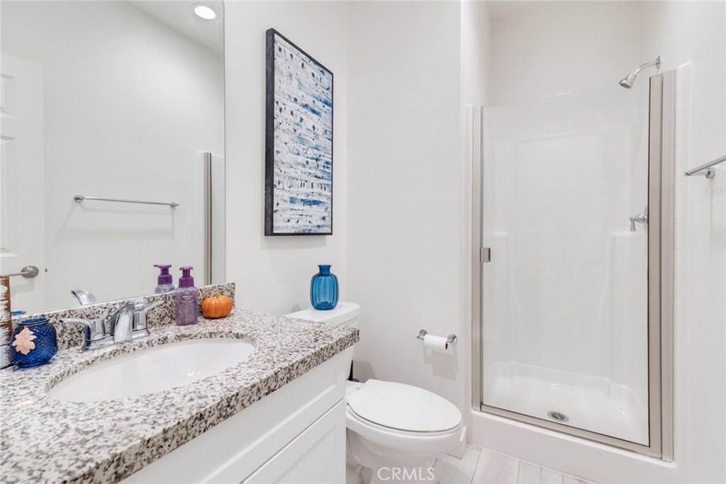 4247 Bravado Court Riverside, CA 92505 - Photo 14 of 33 a bathroom with a granite countertop sink mirror vanity and toilet
