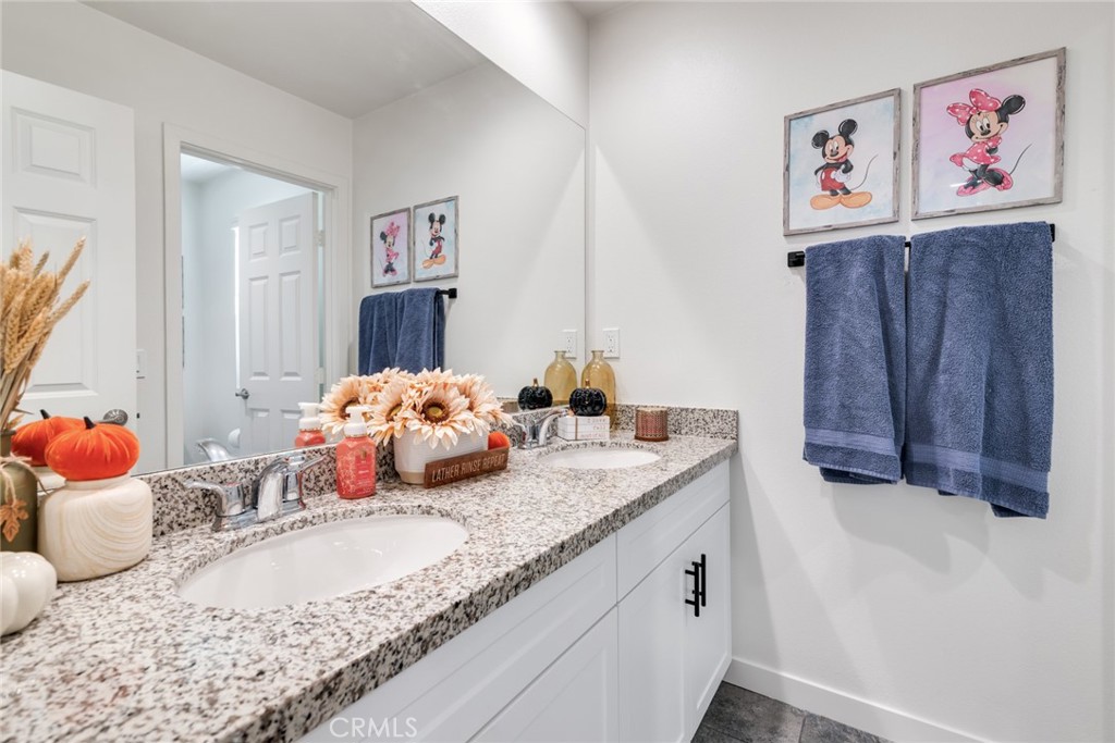 4247 Bravado Court Riverside, CA 92505 - Photo 17 of 33 a bathroom with a granite countertop sink and a mirror
