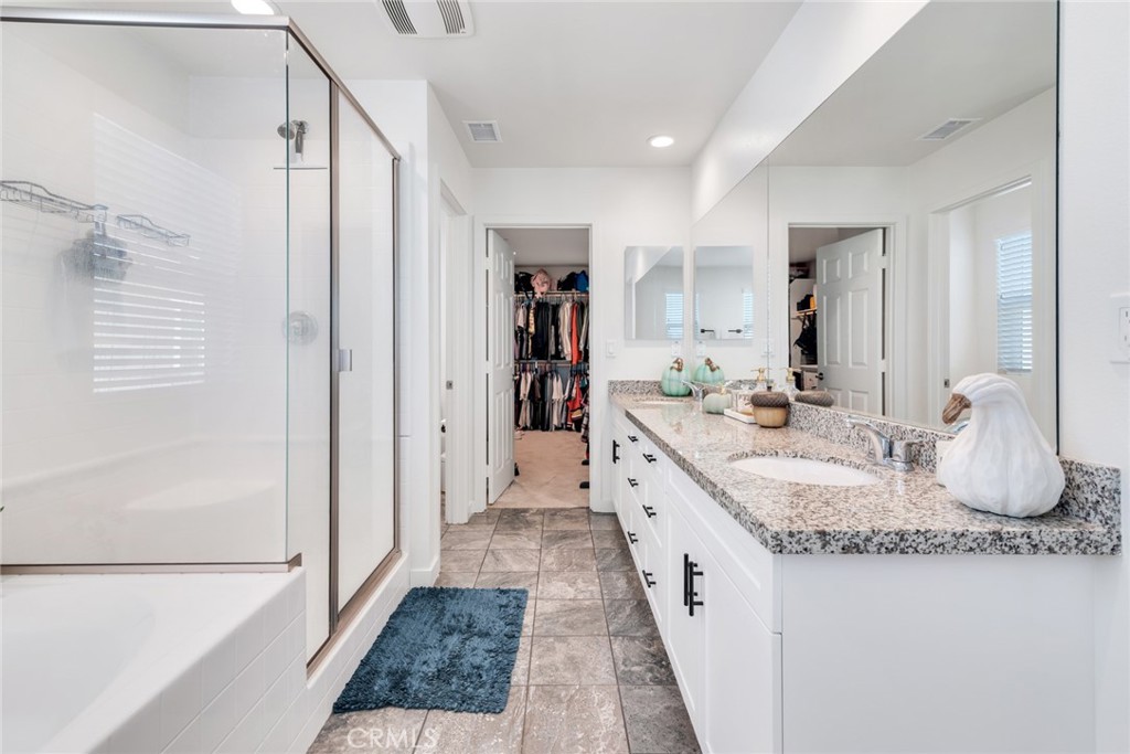 4247 Bravado Court Riverside, CA 92505 - Photo 26 of 33 a bathroom with a granite countertop sink a mirror and shower