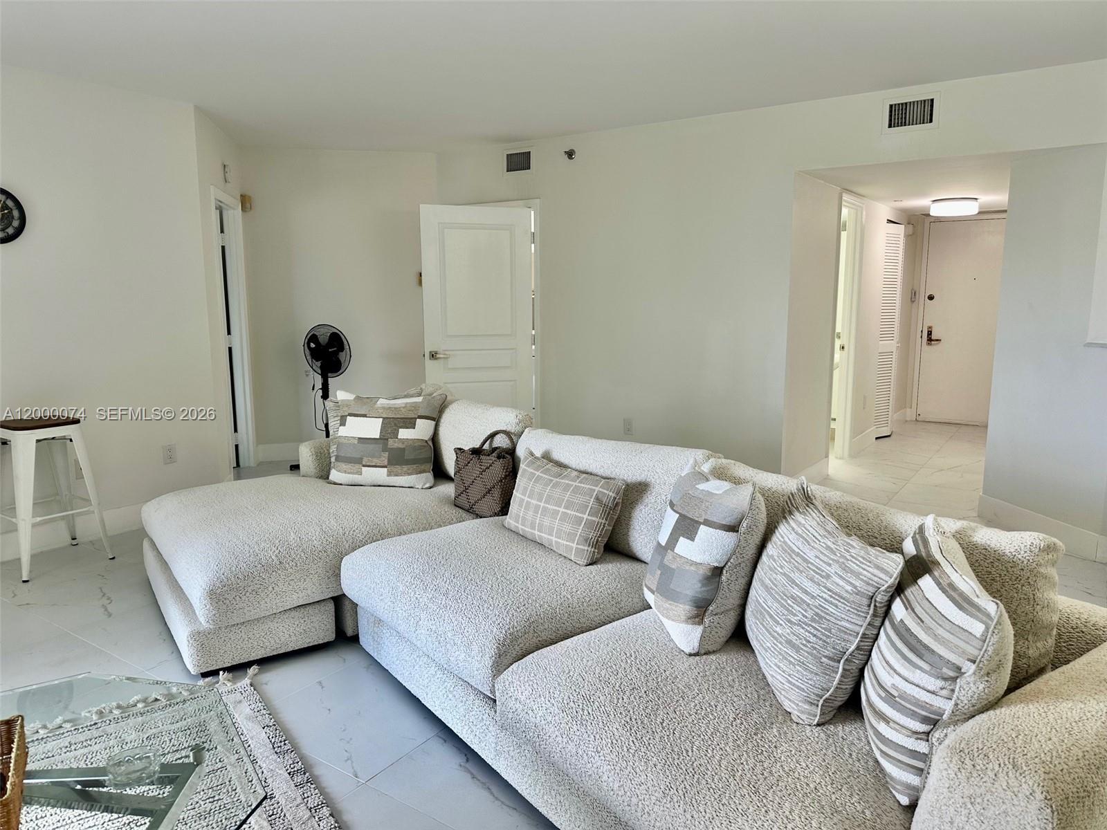 8925 Collins Avenue, Unit 2J Surfside, FL 33154 - Photo 12 of 63 a living room with furniture and a mirror
