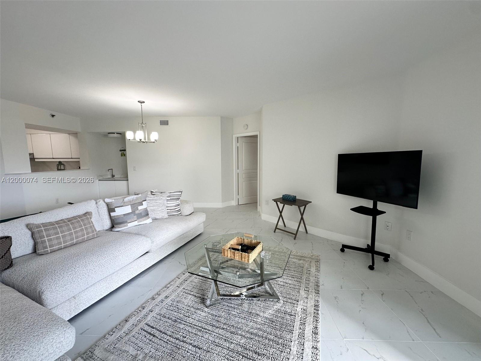 8925 Collins Avenue, Unit 2J Surfside, FL 33154 - Photo 13 of 63 a living room with furniture and a flat screen tv