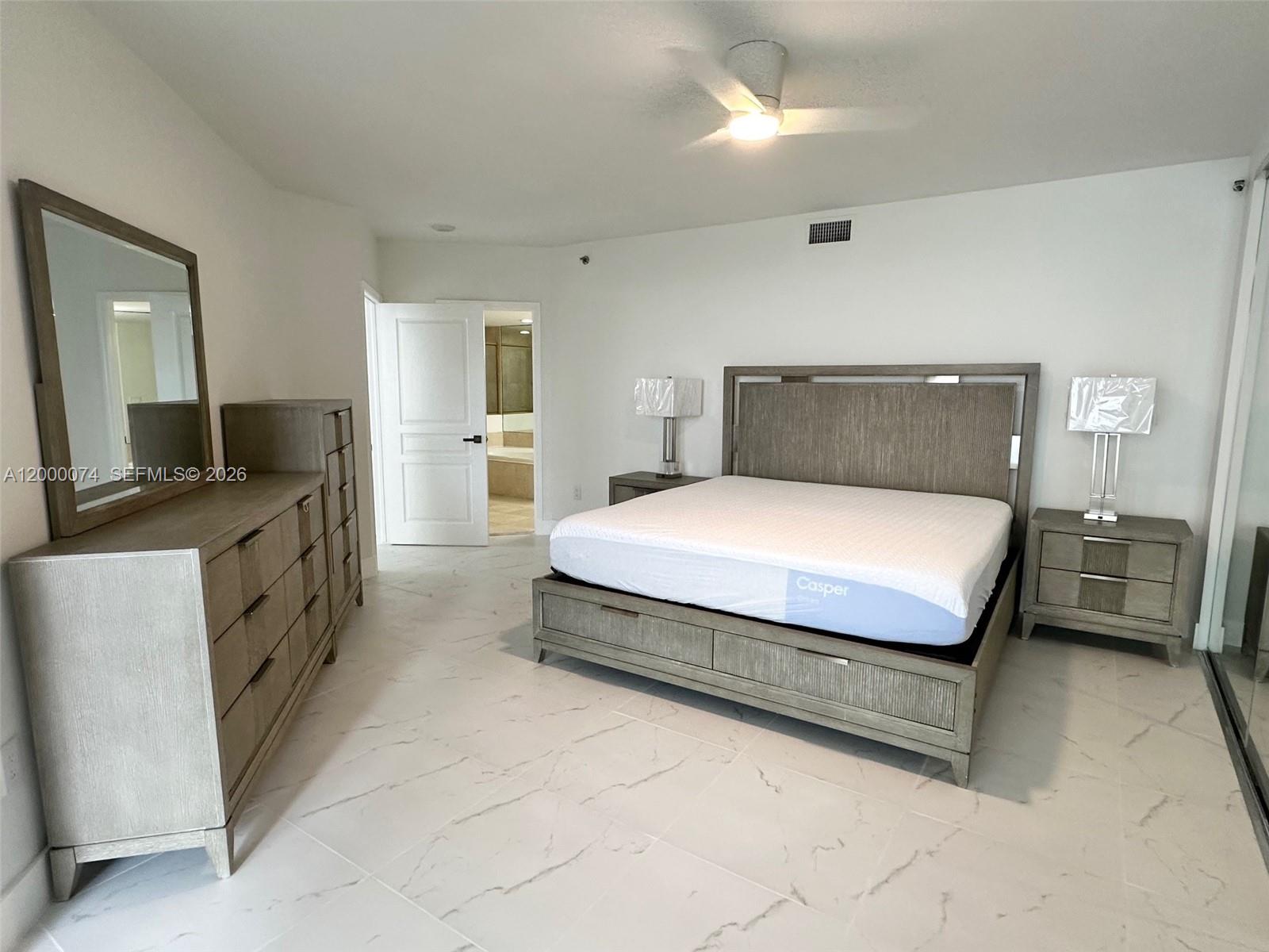 8925 Collins Avenue, Unit 2J Surfside, FL 33154 - Photo 18 of 63 a spacious bedroom with a bed and furniture