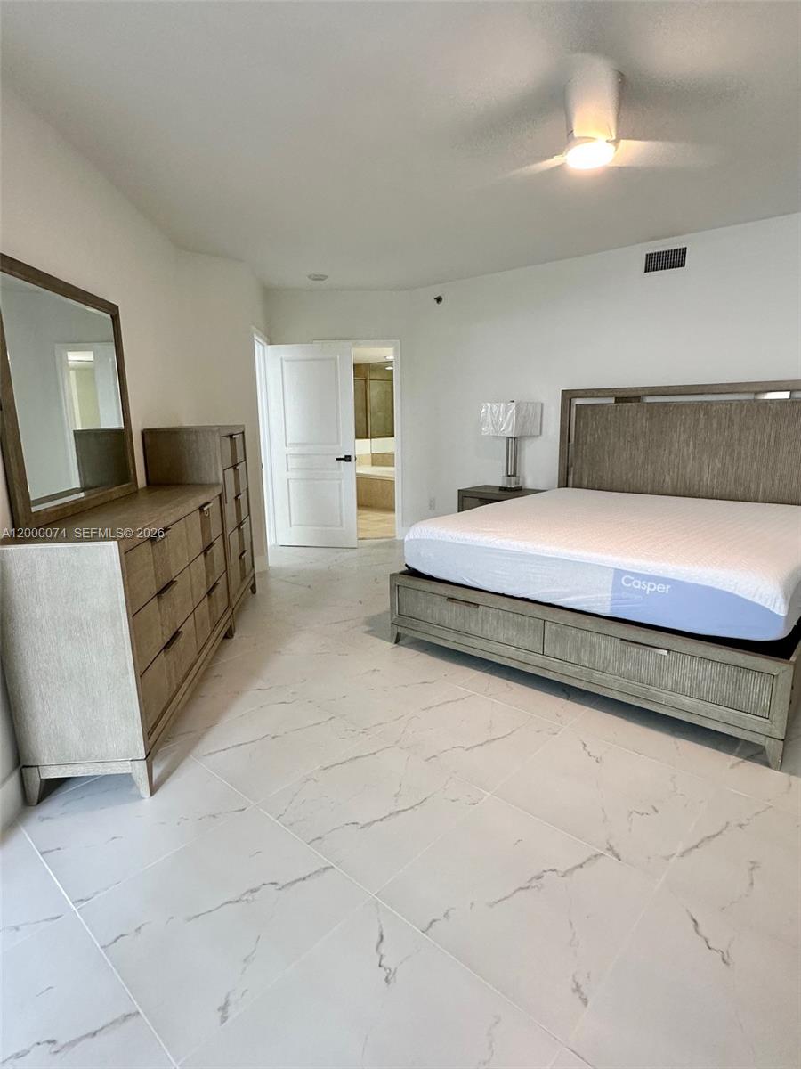 8925 Collins Avenue, Unit 2J Surfside, FL 33154 - Photo 19 of 63 a spacious bedroom with a bed and furniture