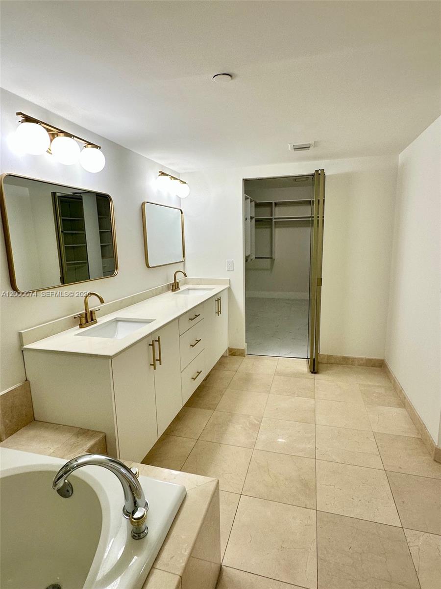 8925 Collins Avenue, Unit 2J Surfside, FL 33154 - Photo 24 of 63 a bathroom with a sink mirror and toilet