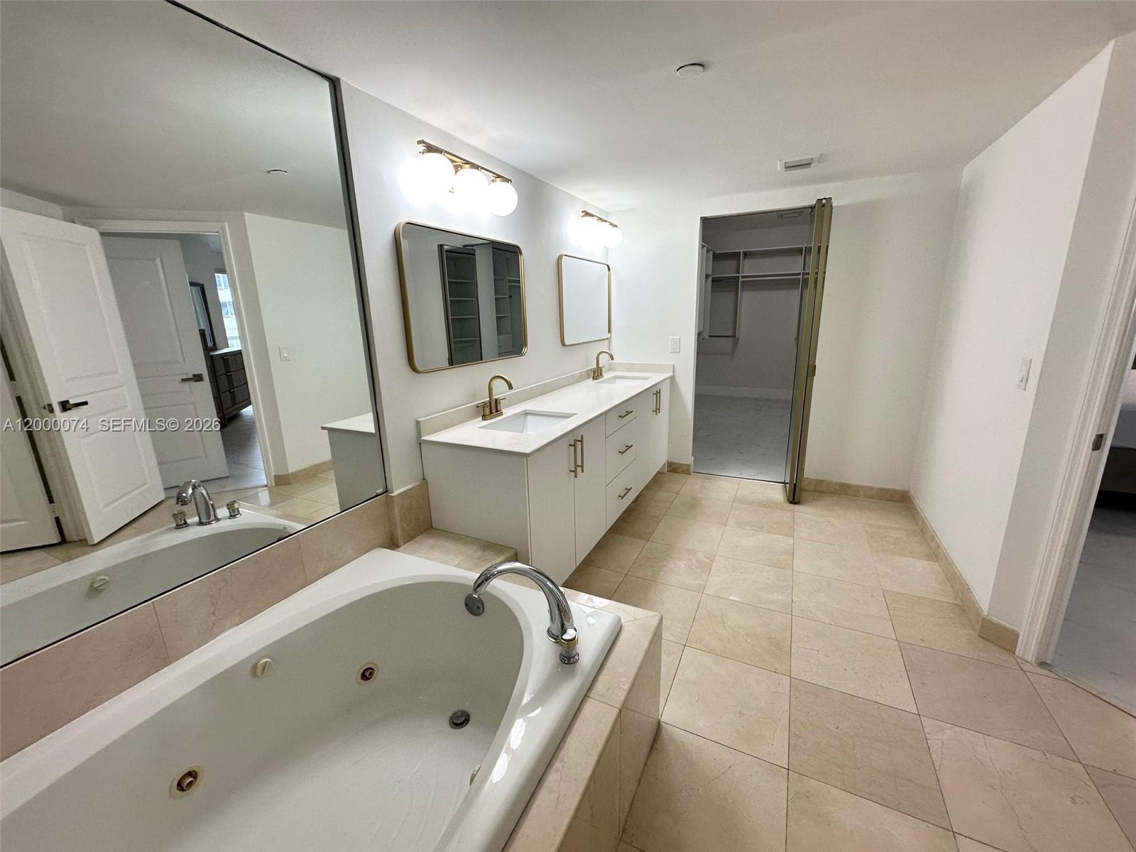 8925 Collins Avenue, Unit 2J Surfside, FL 33154 - Photo 25 of 63 a bathroom with a tub sink and mirror