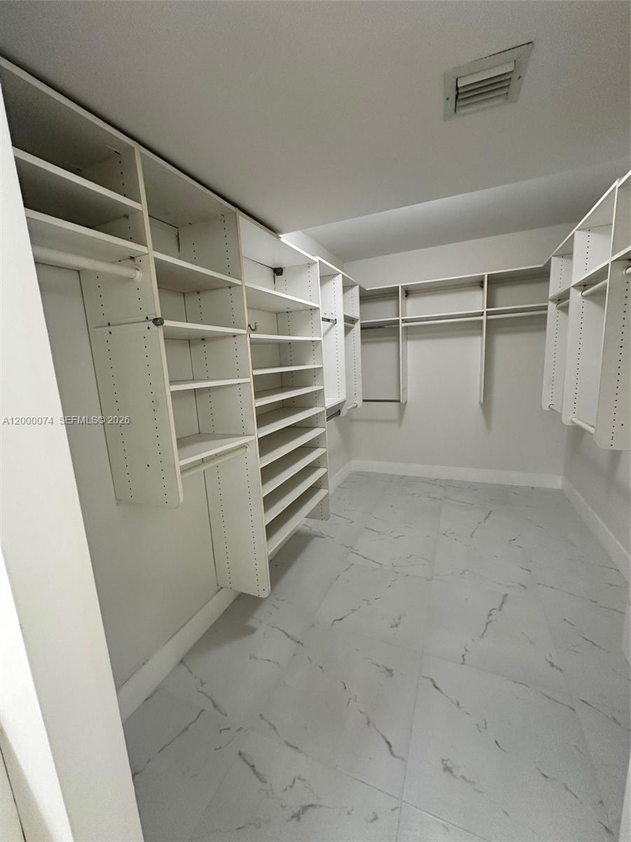 8925 Collins Avenue, Unit 2J Surfside, FL 33154 - Photo 26 of 63 a view of walk in closet with empty racks