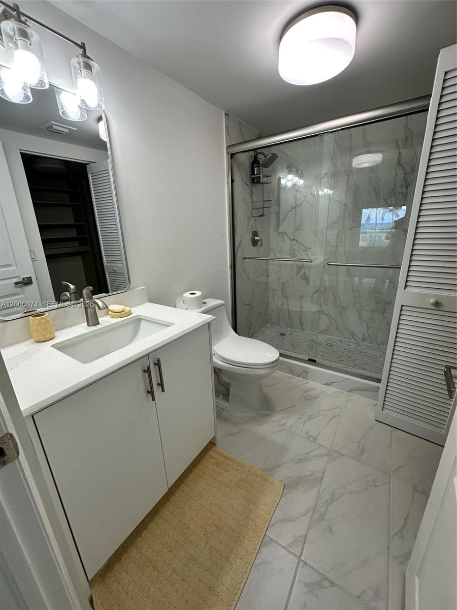 8925 Collins Avenue, Unit 2J Surfside, FL 33154 - Photo 35 of 63 a bathroom with a sink a toilet and shower