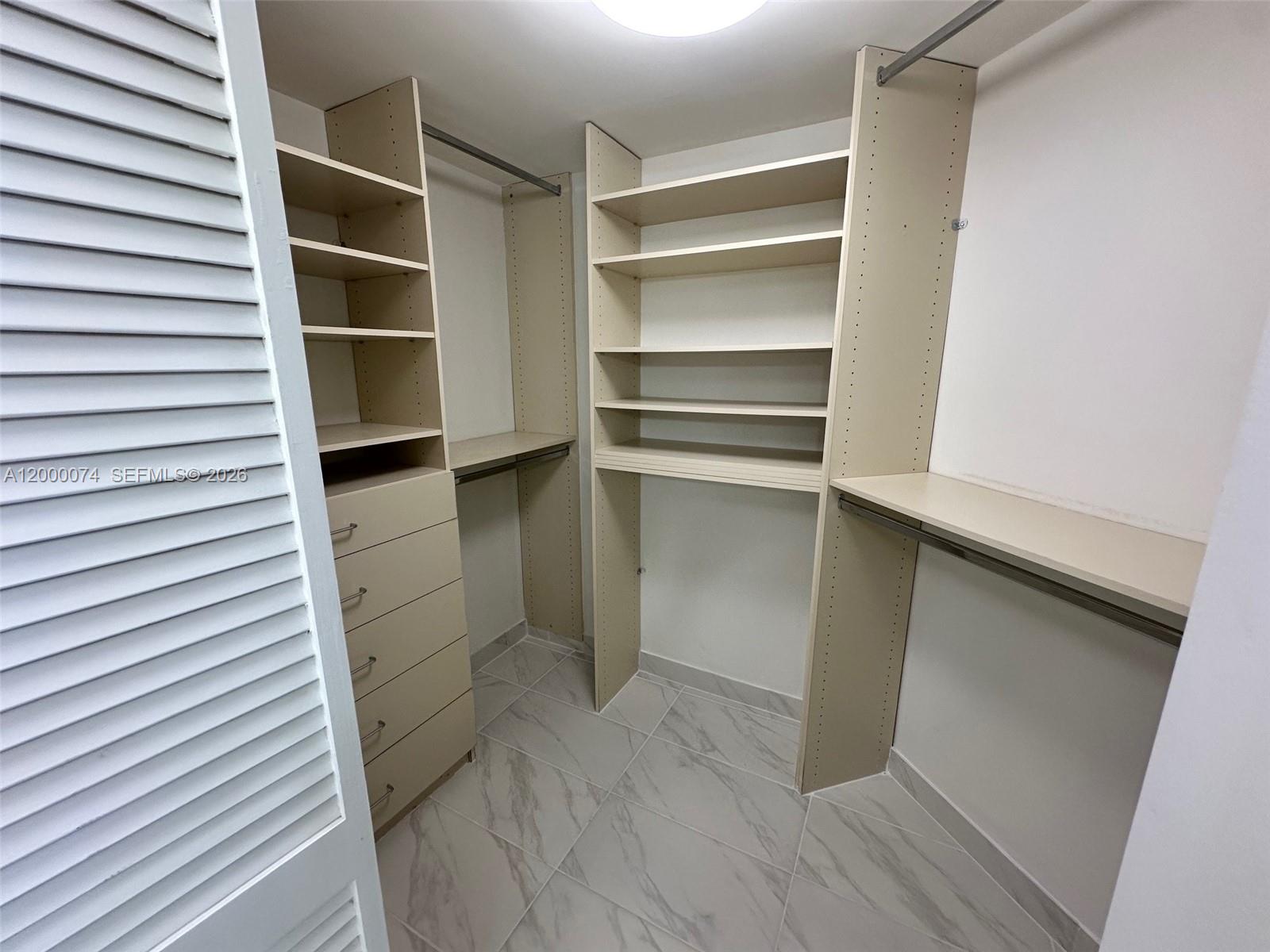 8925 Collins Avenue, Unit 2J Surfside, FL 33154 - Photo 37 of 63 a view of walk in closet with empty racks