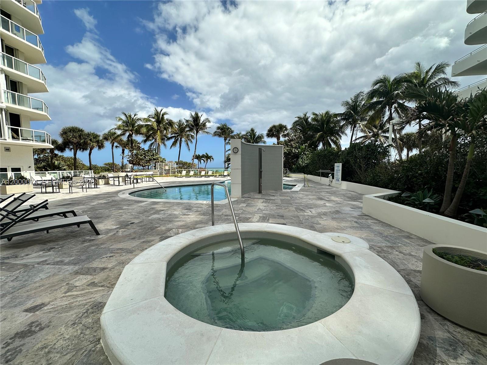 8925 Collins Avenue, Unit 2J Surfside, FL 33154 - Photo 55 of 63 a swimming pool with outdoor seating and barbeque oven