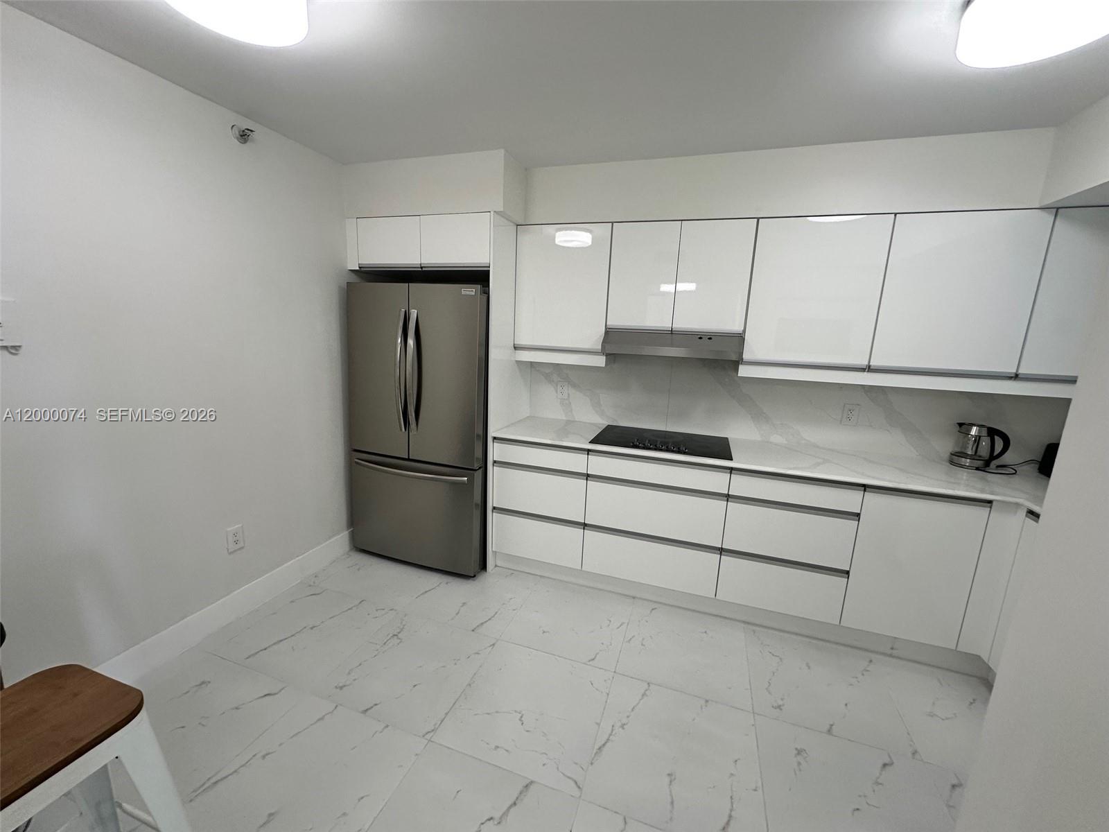 8925 Collins Avenue, Unit 2J Surfside, FL 33154 - Photo 6 of 63 a kitchen with a refrigerator and cabinets