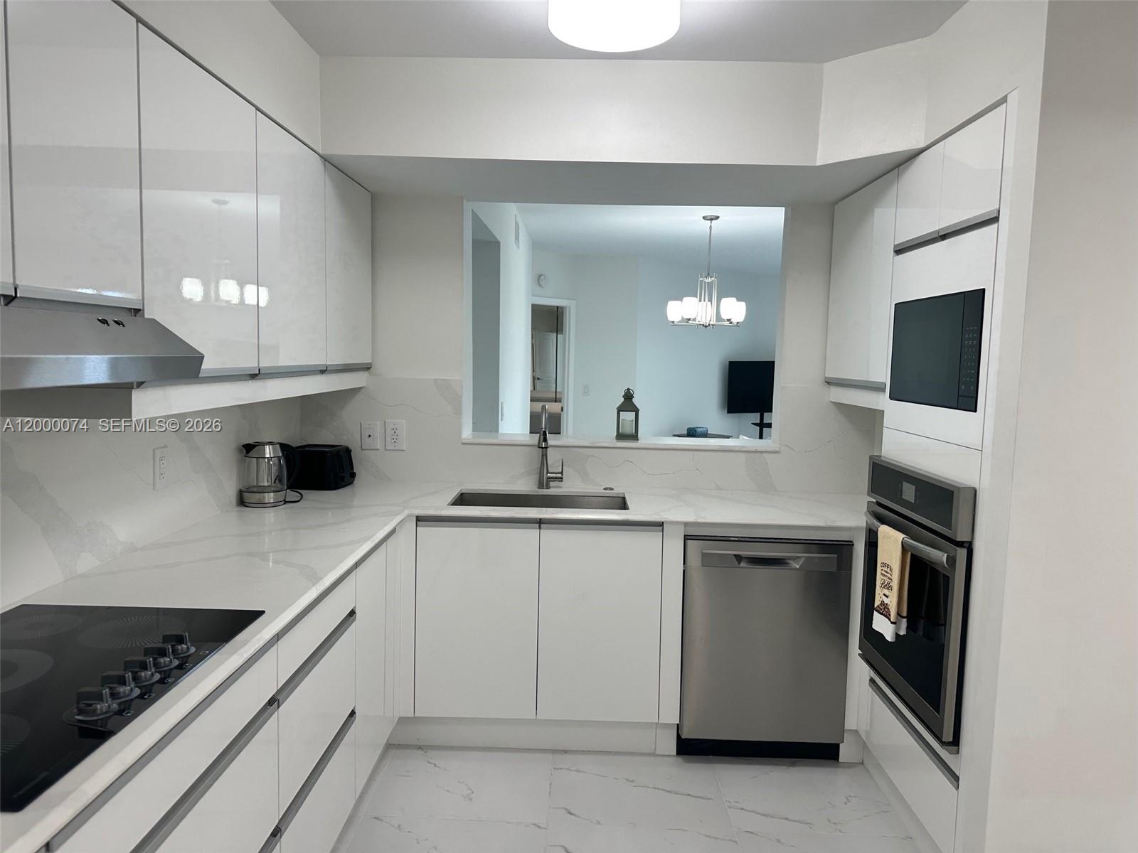 8925 Collins Avenue, Unit 2J Surfside, FL 33154 - Photo 7 of 63 a kitchen with a sink and cabinets