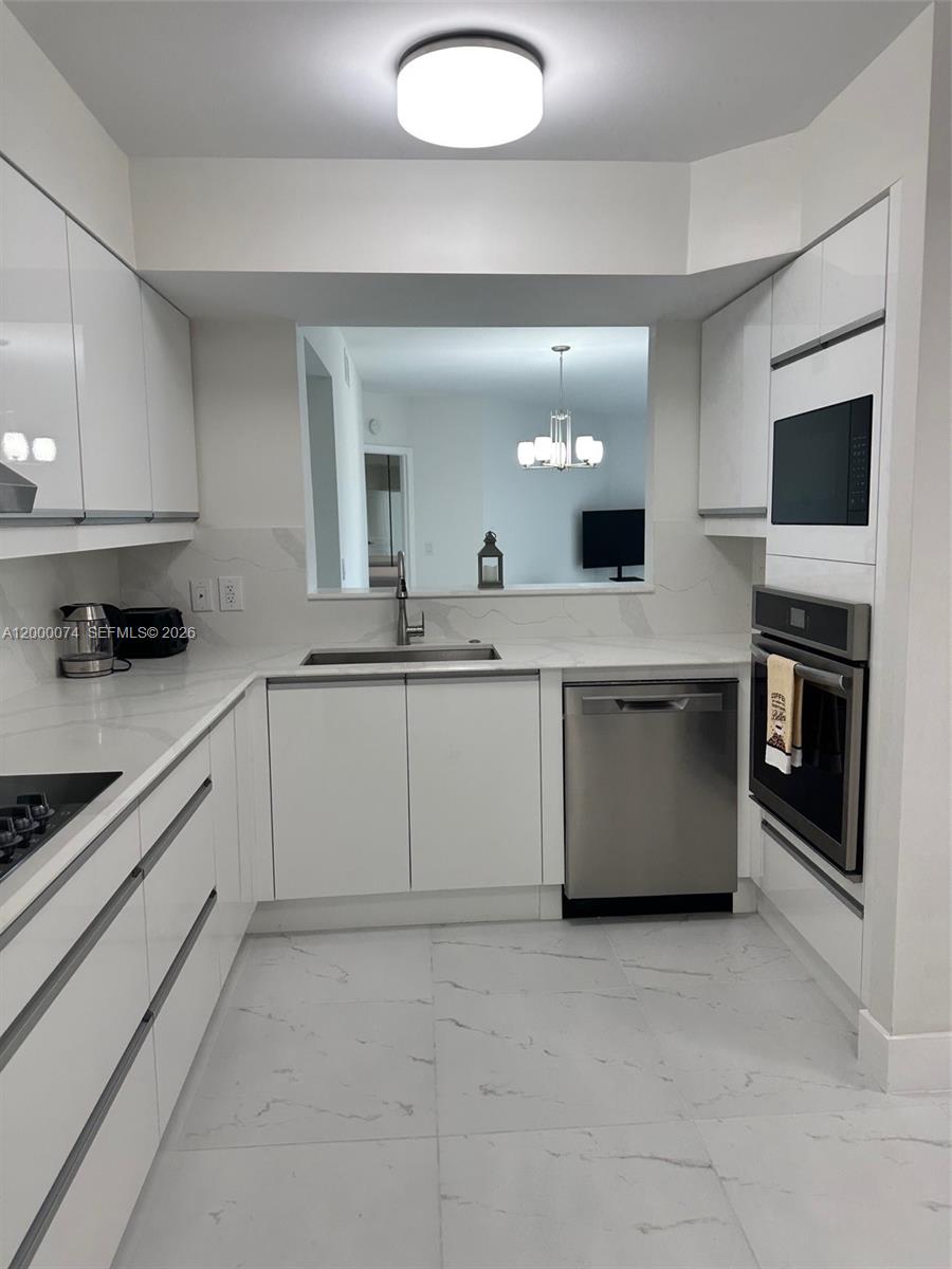 8925 Collins Avenue, Unit 2J Surfside, FL 33154 - Photo 8 of 63 a kitchen with a sink stove and microwave