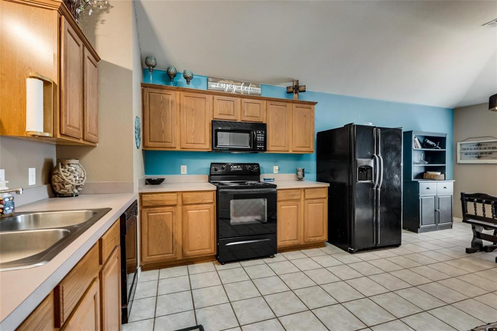1202 Halifax Lane Forney, TX 75126 - Photo 2 of 5 a kitchen with a sink a refrigerator and a stove top oven