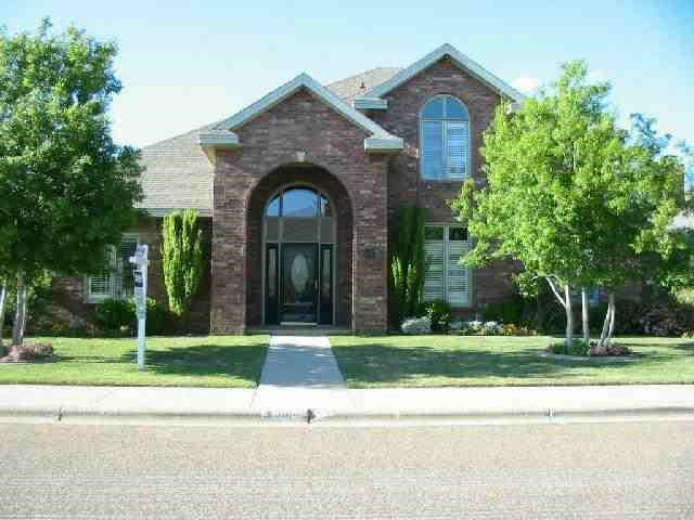 a view of a brick house with a yard