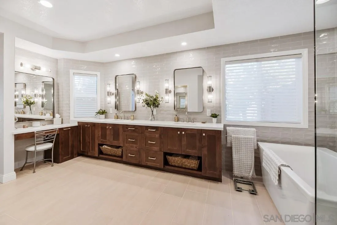 12904 Stone Canyon Road Poway, CA 92064 - Photo 21 of 72 a bathroom with a double vanity sink a mirror a bathtub and next to a window