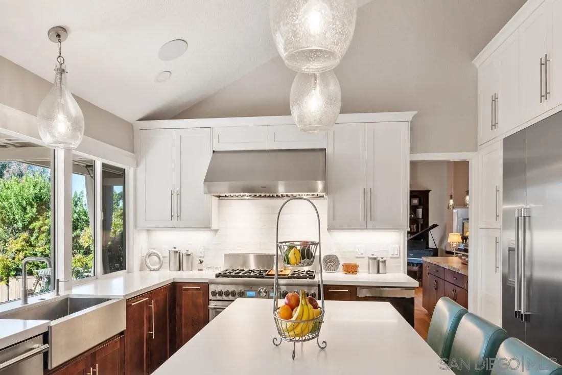 12904 Stone Canyon Road Poway, CA 92064 - Photo 38 of 72 a kitchen with stainless steel appliances a dining table and chairs