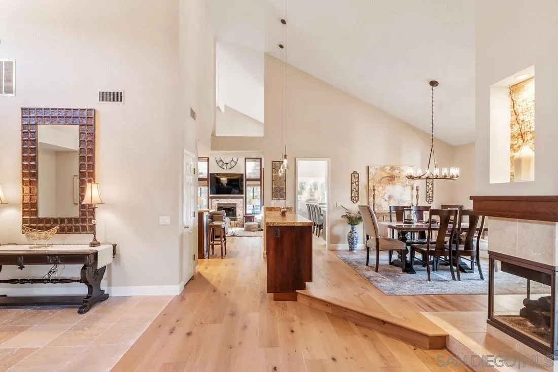 12904 Stone Canyon Road Poway, CA 92064 - Photo 45 of 72 a dining hall with couches a dining table and chairs with wooden floor
