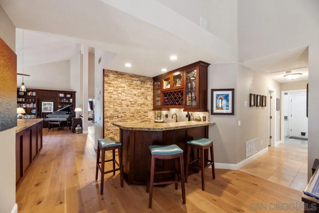 12904 Stone Canyon Road Poway, CA 92064 - Photo 49 of 72 a kitchen with stainless steel appliances granite countertop dining table chairs and wooden floor