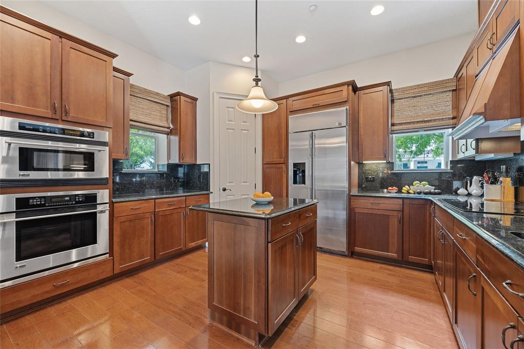 1027 Juel Street Orlando, FL 32814 - Photo 27 of 78 a kitchen with stainless steel appliances granite countertop a stove top oven a sink and a refrigerator