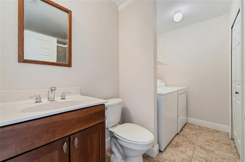 1027 Juel Street Orlando, FL 32814 - Photo 65 of 78 a bathroom with a toilet sink and mirror