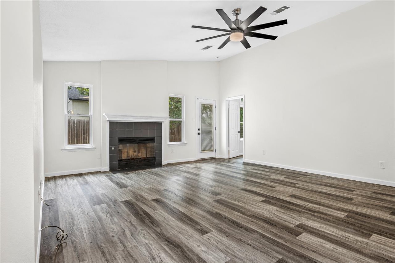 4004 Danli Lane Austin, TX 78749 - Photo 30 of 40 a view of a livingroom with a fireplace a ceiling fan and wooden floor