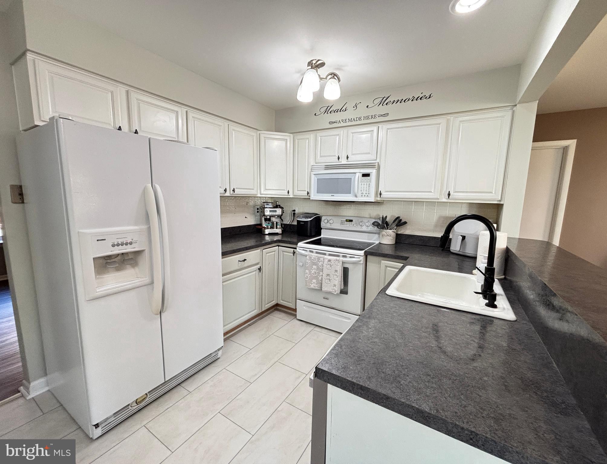 1011 South Beecham Road Williamstown, NJ 08094 - Photo 11 of 23 a kitchen with white cabinets and refrigerator