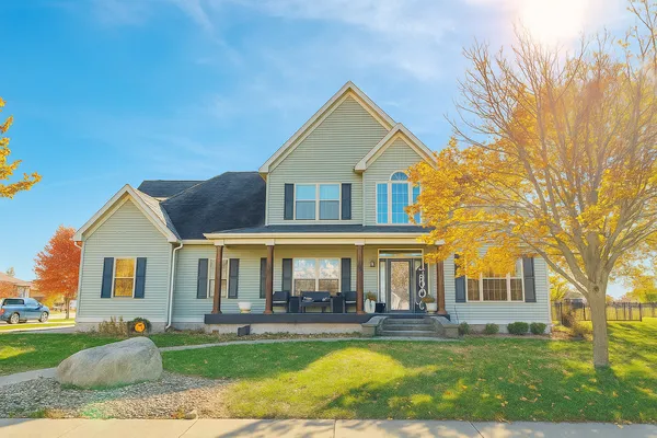 a front view of a house with swimming pool and porch with furniture